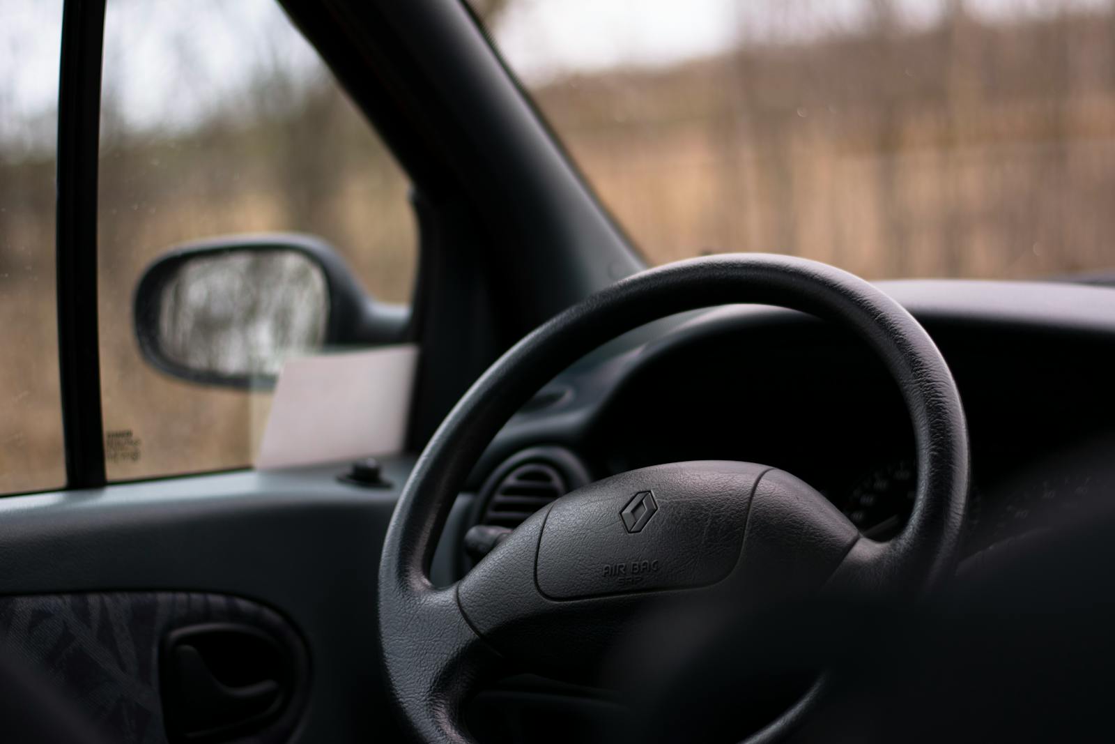 Detailed close-up shot of a car's steering wheel and interior, no people visible.